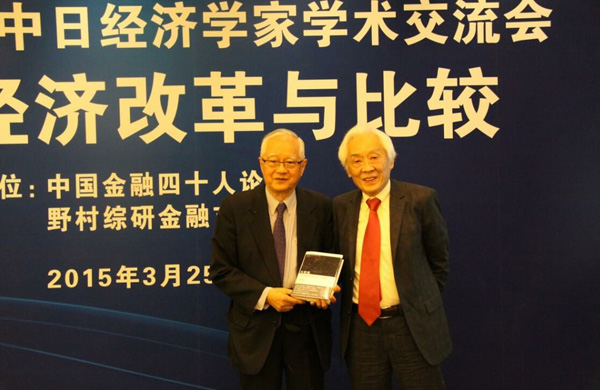 「日中経済学者学術交流会」で行われた青木先生（右）から呉先生（左）への書籍贈呈セレモニー