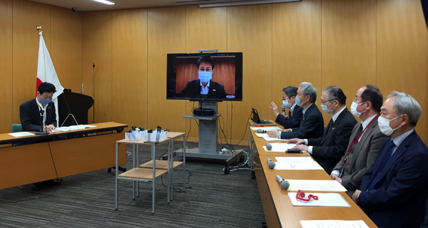 西村康稔内閣府特命担当大臣（左）と提言内容を説明する小林PD（右奥）
